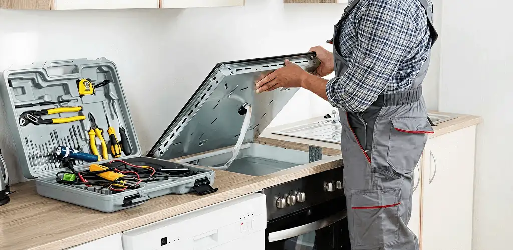 Handyman repairing a cooktop and checking wiring connections in Stamford, CT