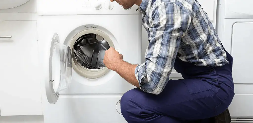 Handyman inspecting a dryer drum and internal parts for repair in Stamford, CT