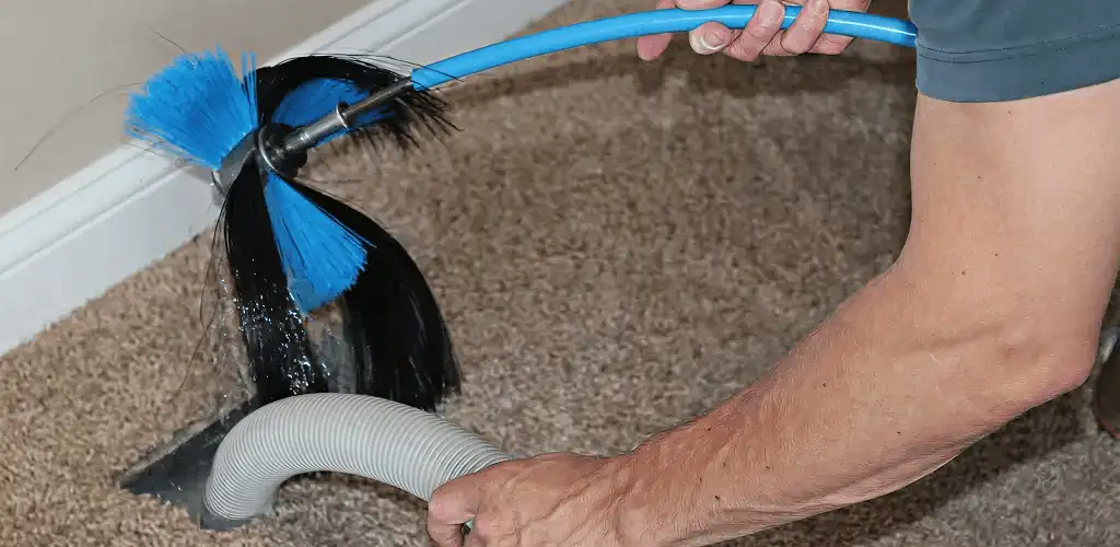 Dryer vent cleaning technician brushing lint from a vent line in Stamford, CT