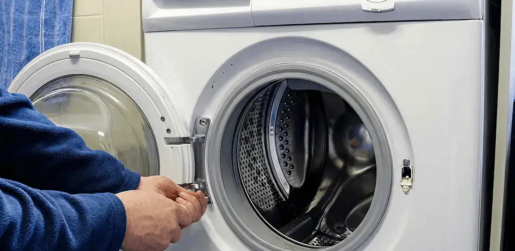 Washing machine repair handyman checking a front-load washer door and latch in Stamford, CT