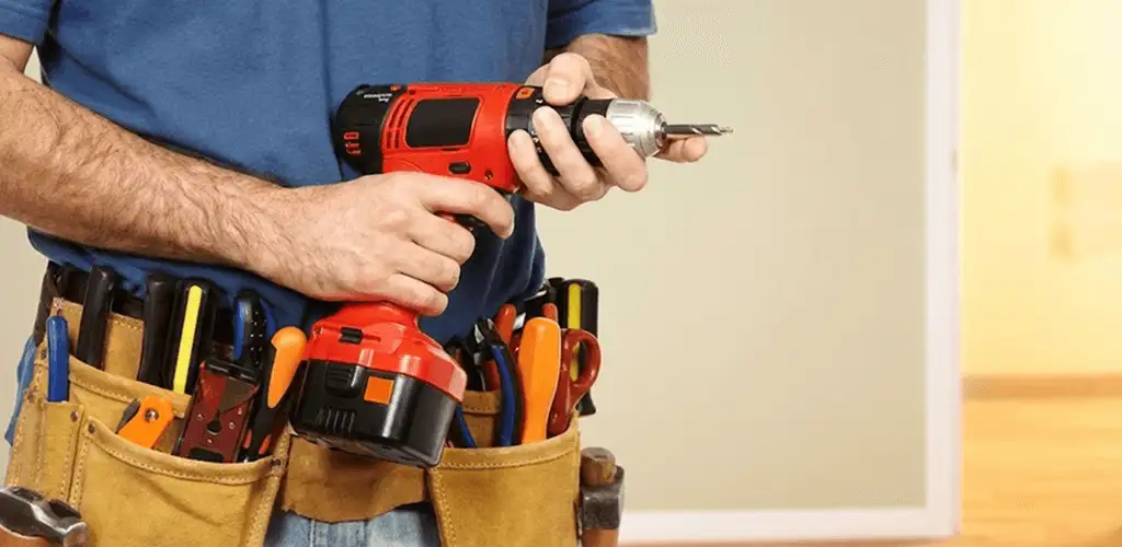 Handyman holding a power drill for home repairs and installations in Stamford, CT