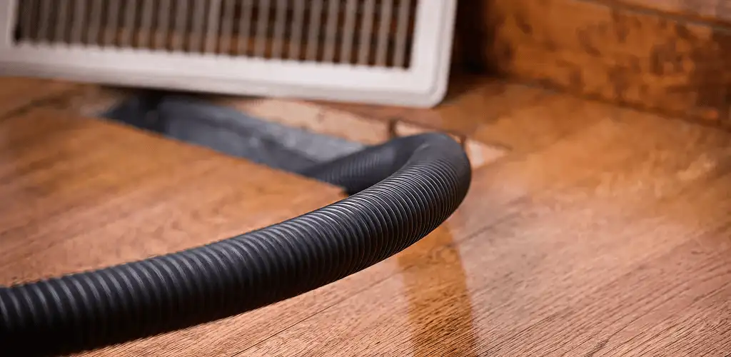 Air duct cleaning hose inserted into a floor vent for ductwork cleaning in Stamford, CT